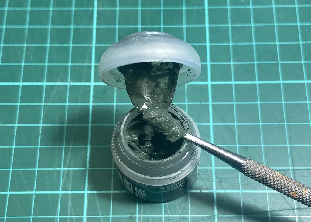 Close up of a Liquid green stuff used in Minichix Studio article on sculpting scars on miniatures, showing off the consistency of the putty.